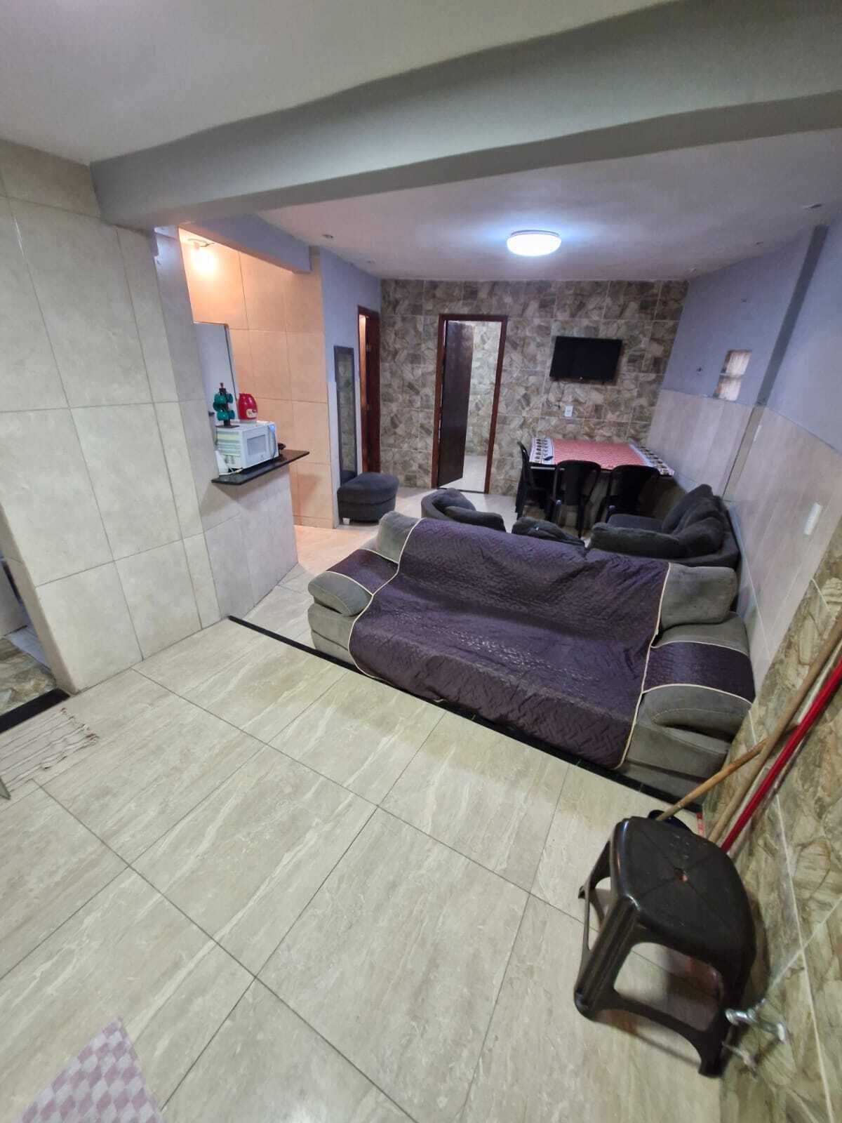A room with a bed, a small table, a chair, and a television.