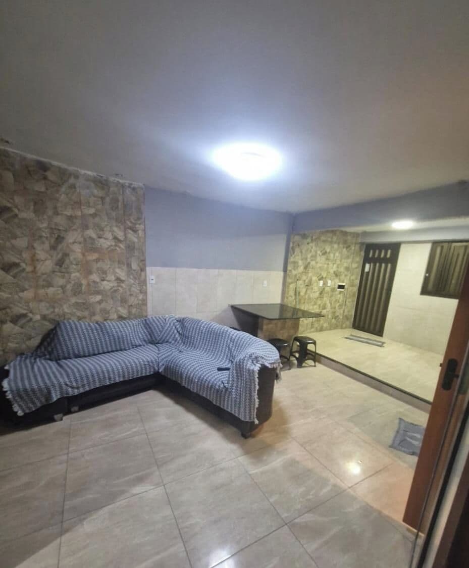 Una habitación con sofá, una mesita y un banco.