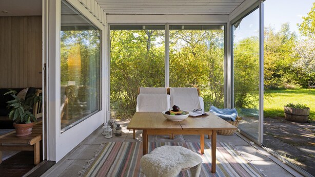 A covered patio with a wooden table, two chairs, a bowl of fruit, and a small stool. - Cozy home in Vejby with WiFi (Vejby)