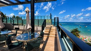 A rooftop terrace with outdoor seating, a glass balustrade, and a view of the ocean. - Amazing flat on the sand (Ipojuca)
