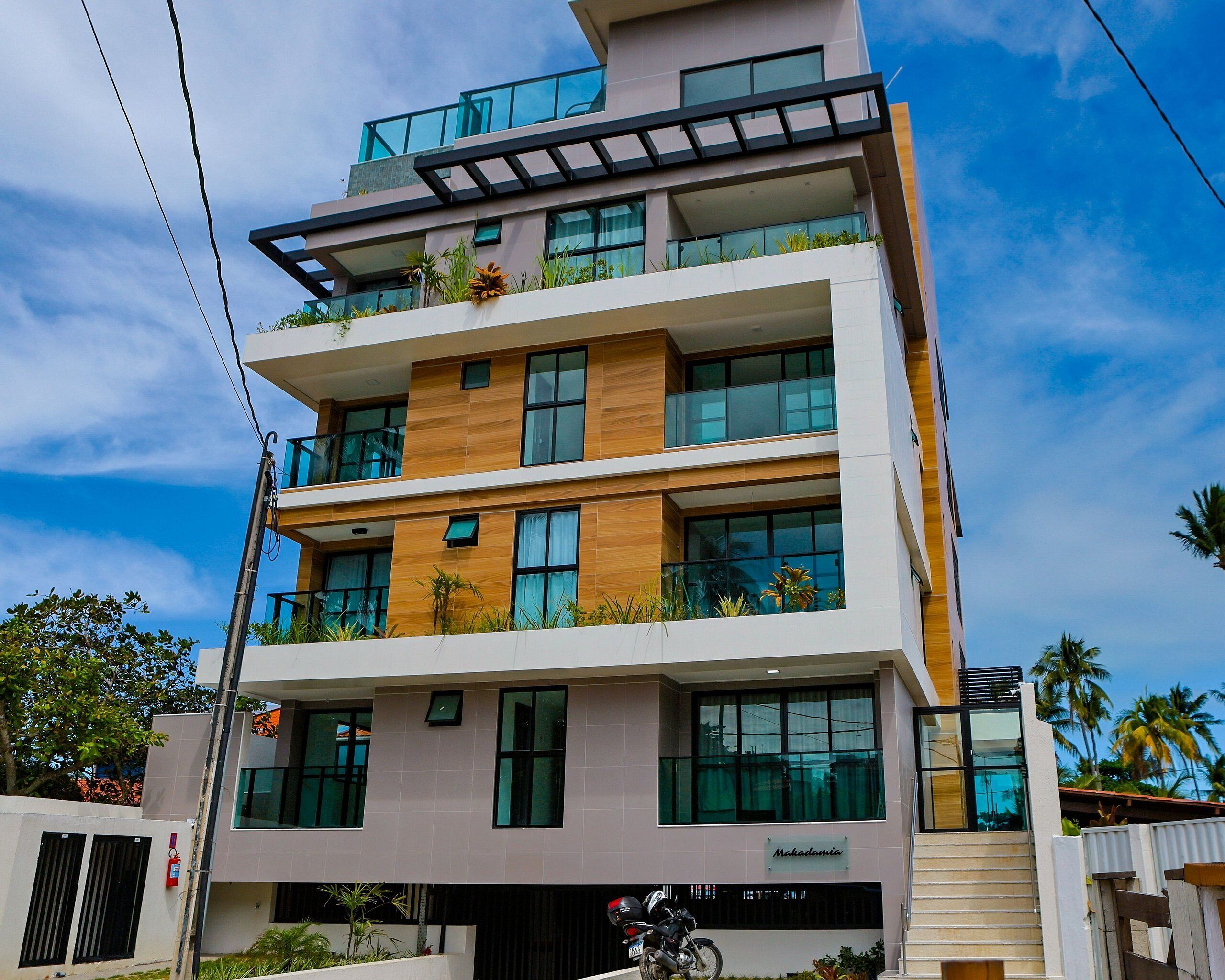 A multi-story building with balconies, large windows, and a sign that reads 'Makademia.'