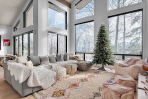 A spacious living room with a large sectional sofa, a small Christmas tree, and a colorful rug. - Scenic Alpine Getaway, Hot Tub, Sauna, Views (Park City)