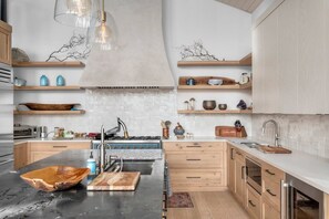 A modern kitchen with a central island, wooden cabinets, and a variety of kitchenware.