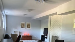 Una sala moderna con comedor, chimenea y televisor.