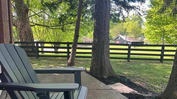 A wooden deck with a bench and picnic table, surrounded by trees and a fenced area. - Welcome to Bourbon Oak Smokehouse, in the heart of Bardstown, KY (Bardstown)
