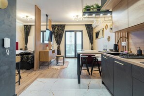Relax in a spacious room with a sofa, flat-screen TV, dining area, and kitchenette.