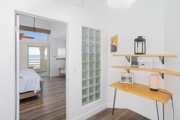 A bedroom with a wooden bed, a green window, and a wooden shelf with a lantern and a picture. - Right on the Sand (Oceano)