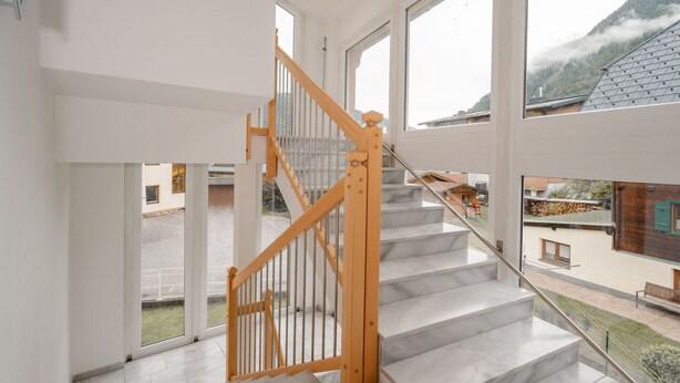 A modern staircase with wooden railings and marble steps leading to an upper floor. - Lovely apartment for 3 guests with TV and terrace (Bad Hofgastein)