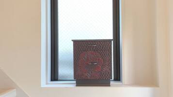 A small window with a decorative cabinet below it.