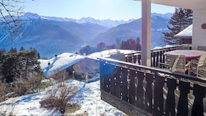 A mountain view from a balcony with a wooden railing, a table, and chairs. - Wonderful private villa for 10 guests with WIFI, TV, terrace and panoramic view (Bluche)