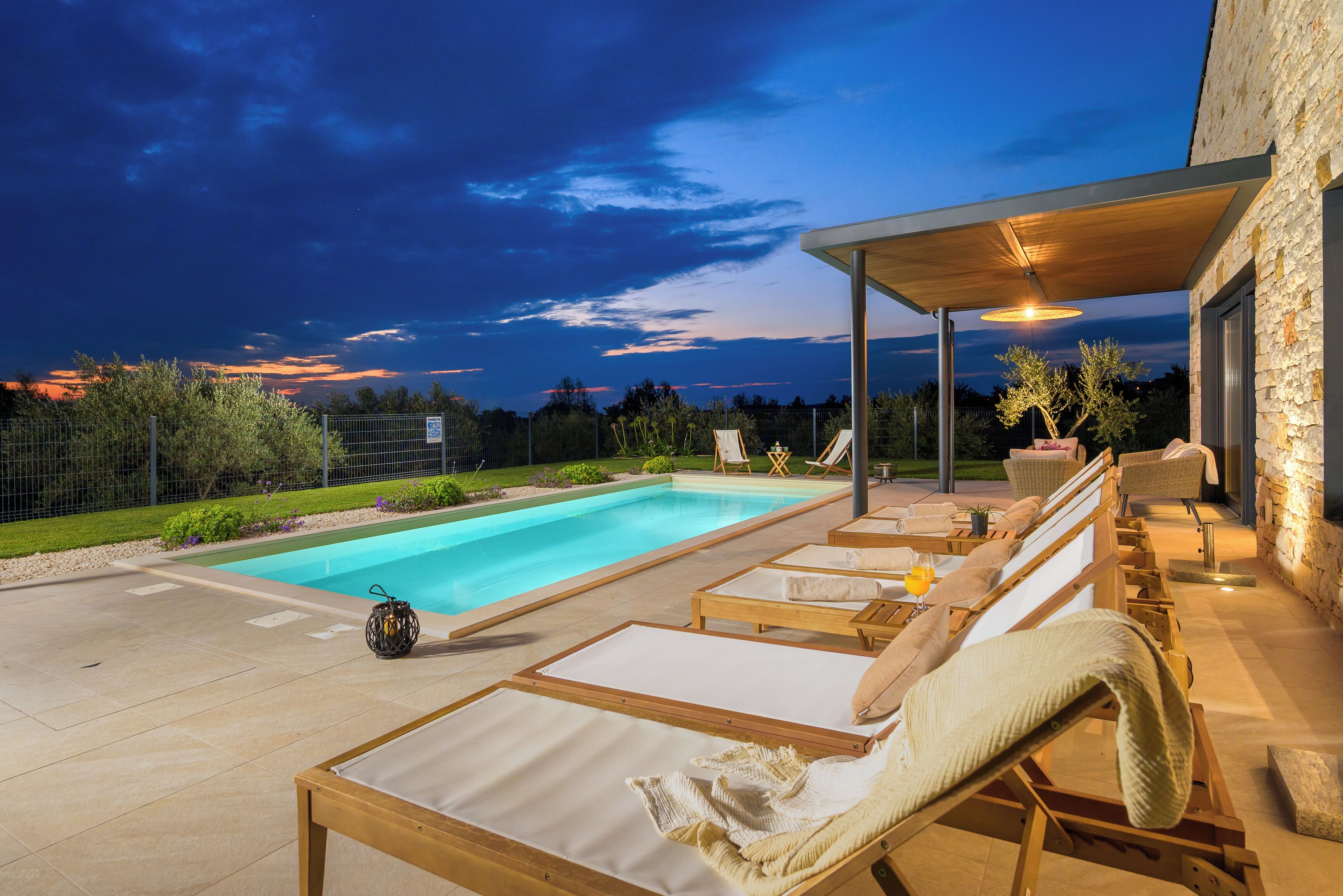 Une piscine avec des chaises longues et un espace de repos abrité.