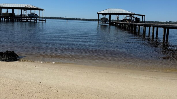 A beach with two wooden piers extending into calm water. - Nice House in Perdido Bay (Lillian)