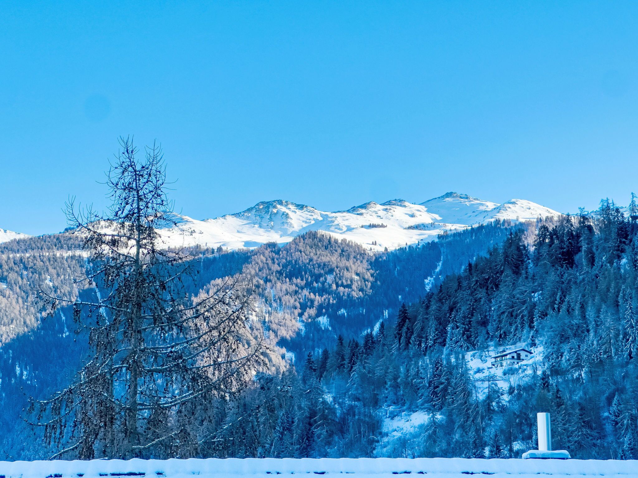 A snow-covered mountain landscape with a clear sky.