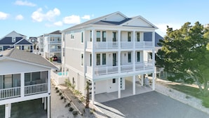 A multi-story beachfront property with balconies, a covered patio, and a pool area. - "Sea Ya at Holden" BRAND NEW 4 Bedroom, 4.5 Bath Home w/ PRIVATE POOL and Elevator! (Holden Beach)