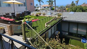 A residential area with a balcony, outdoor seating, and a view of neighboring houses. - WindanSea Ocean View (San Diego)
