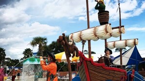 Ein piratenthemen Wasserpark mit Schiff-Gebäude und einer Person in Piratenkostüm.