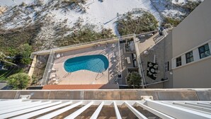 Ein Pool auf dem Dach mit Blick auf einen Strand und ein Gebäude im modernen Stil.