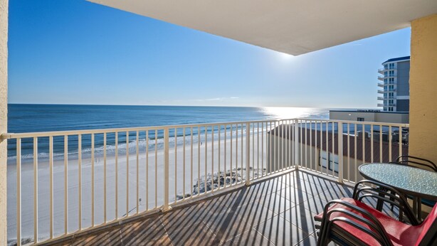 Ein Balkon mit Blick auf Strand und Meer.