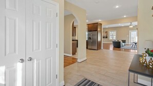 A spacious living area with a kitchen, dining area, and a large white door. - Spacious 3BR Home near Tysons and Metro | Private Yard (Falls Church)