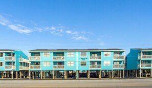 A row of turquoise seaside buildings with balconies, labeled "Lani Kai 728".