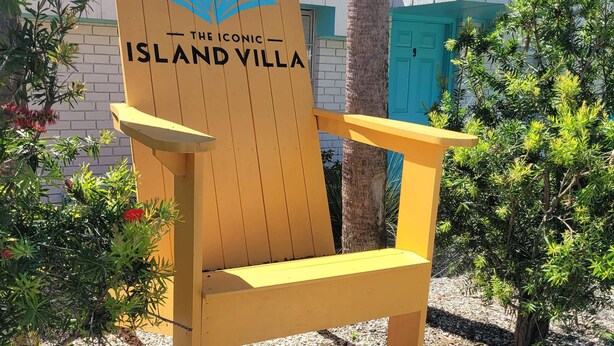 Ein Holzstuhl mit einem Logo und dem Schriftzug "The Iconic Island Villa".