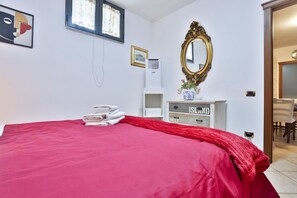A hotel room with a bed, a mirror, a dresser, and a window. - GuestHost - Cozy apartment that can accommodate up to 6 people, located in an independent villa with garden. The apartment is 900 meters from the Circumvesuviana for Naples-Pompei-Sorrento, perfect for traveling in the area and reaching all points of int (San Giorgio a Cremano)