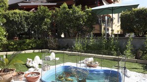 A swimming pool surrounded by potted plants and rocks, with a fence and a building in the background. - GuestHost - Cozy apartment that can accommodate up to 6 people, located in an independent villa with garden. The apartment is 900 meters from the Circumvesuviana for Naples-Pompei-Sorrento, perfect for traveling in the area and reaching all points of int (San Giorgio a Cremano)