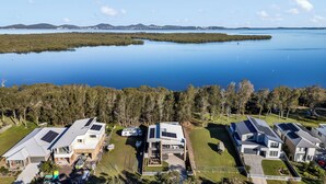 Un quartier résidentiel avec des maisons modernes, des panneaux solaires et une grande étendue d’eau en arrière-plan.