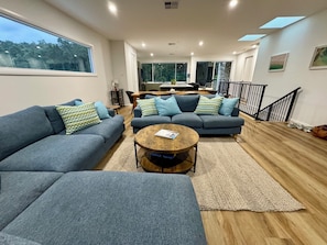 A modern living room with two grey sofas, a wooden coffee table, and a rug.