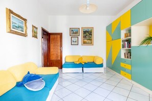 A room with a sofa, a bookshelf, and a door.