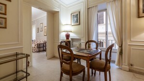 Un comedor con una mesa, sillas, una lámpara y cuadros en la pared.