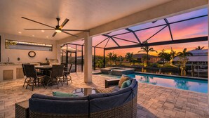 Un espacio al aire libre cubierto con piscina, asientos y zona de comedor.