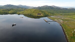 A calm lake with a small sailboat and a dock extending into the water. - Adak Island Inn (Adak Island)