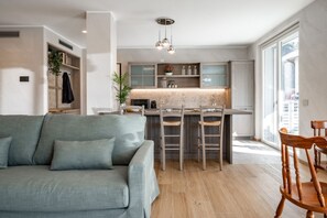 A modern kitchen with a central island, wooden chairs, and a built-in bench.