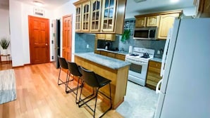 Una cucina moderna con mobili in legno, un piano di lavoro in marmo e un forno integrato.