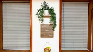 Una stanza con un tavolo di legno scuro, un cesto di snack e un cartello appeso al muro con la scritta "GOOD VIBES ONLY".