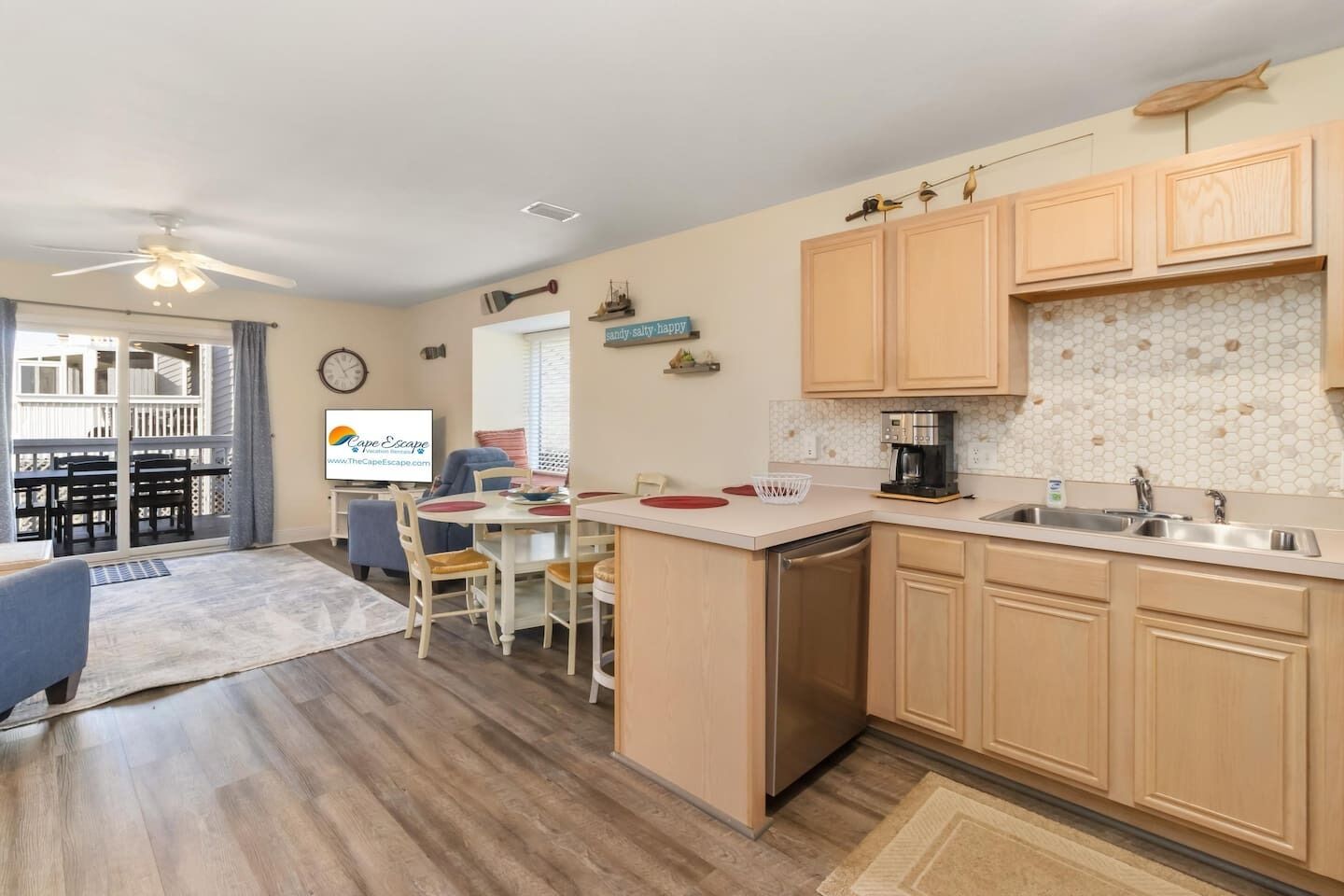 Een keuken met houten kastjes, een koffiezetapparaat en een eethoek met stoelen en een tafel.