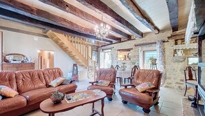 A spacious living room with leather sofas, a wooden coffee table, and a chandelier. - Vacation home Durand by Interhome (Saint Chamarand)