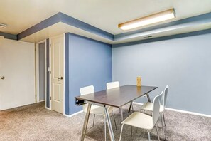 Een vergaderruimte met een donker houten tafel, witte stoelen en een klein decoratief object op de tafel.