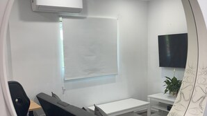 A conference room with a whiteboard, a flat-screen TV, a ceiling fan, and a round mirror with a decorative frame. - Peace and Joy (Para Hills)