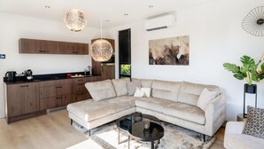Una sala de estar moderna con un sofá modular, una mesita de centro y un ventanal grande.
