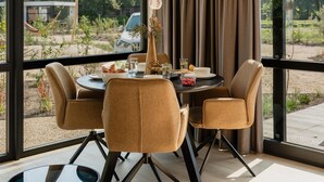 Un comedor con una mesa redonda, cuatro sillas y vista al exterior.