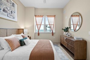 Cozy retreat with a large bed, dresser, and bedside table, perfect for a restful stay.