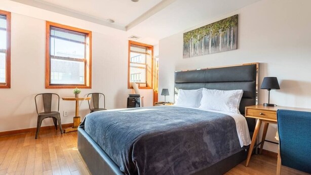 Un dormitorio moderno con una cama grande, un escritorio y dos sillas.
