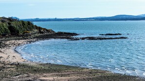 En kustnära strand med klippor och fri utsikt över havet.