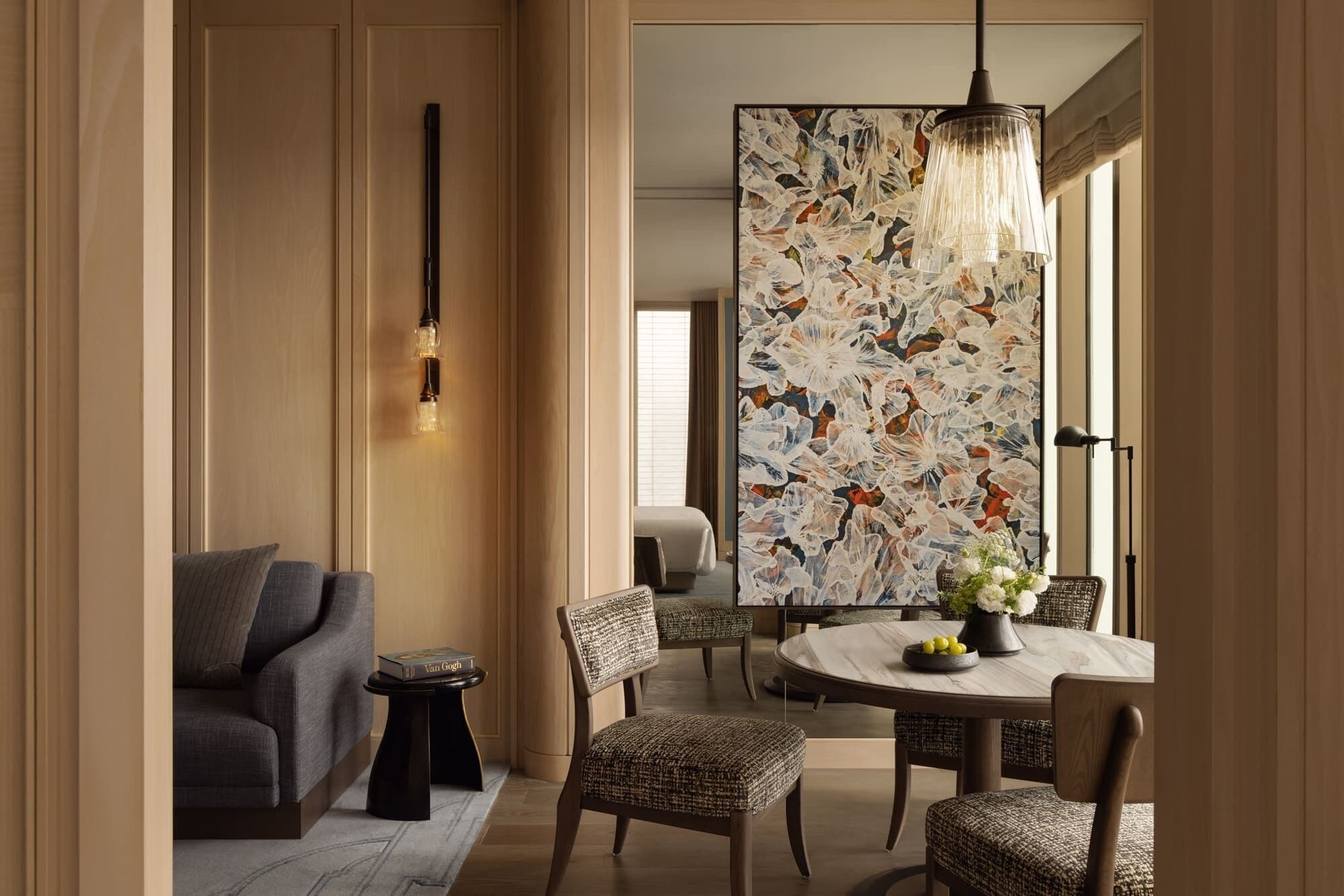Un espace repas moderne avec une table ronde, des chaises en osier et un luminaire contemporain.