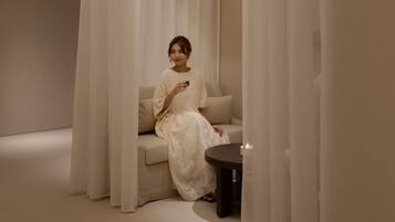 A room with a sofa and a small table, surrounded by white curtains.