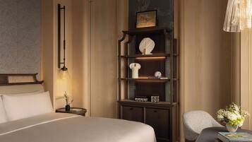 A modern bedroom with a large bed, a wooden nightstand, a bookshelf, and a decorative chair.