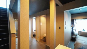 A hotel room with a bed, a desk, a chair, and a wardrobe.