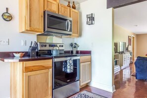 Una cocina moderna con armarios de madera, una estufa de acero inoxidable y un microondas.